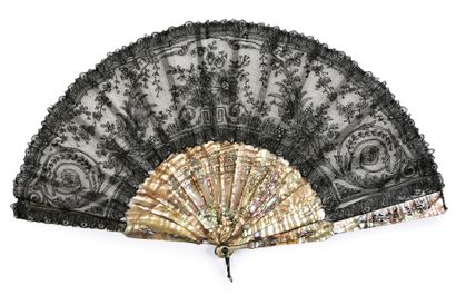null Tinted mother-of-pearl, circa 1880
Folded fan, the leaf in black lace, with...