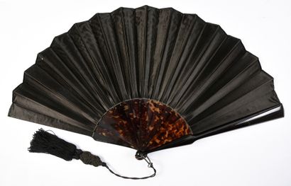 null The Castiglione, circa 1890
Folded fan, the double sheet of black satin painted...