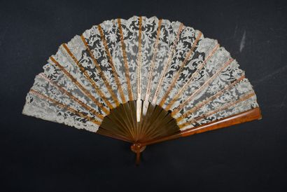 null Delicate volutes, circa 1900
Small folded fan, the leaf in bobbin lace decorated...