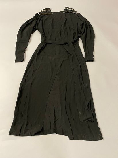  Two dresses, circa 1930, one with long sleeves in black silk crepe, the more remarkable...