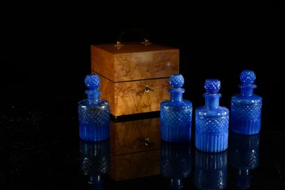 null Perfume set including four blue cut glass bottles and their stopper, in a cubic...