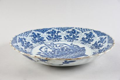 CHINE Large porcelain dish with white and blue decoration of a flowering basket surrounded...