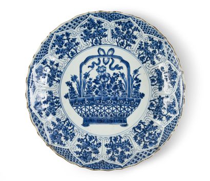 CHINE Grand plat en porcelaine à décor blanc et bleu d'un panier fleuri entouré d'une...