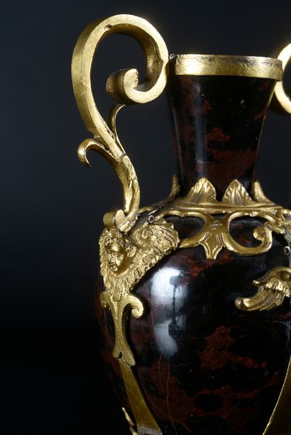 null A pair of mahogany obsidian vases, the gilded copper frame decorated with winged...