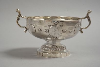 Silver bowl with two handles, resting on...