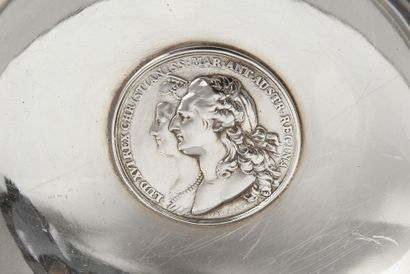 null Silver bowl with two handles, resting on a pedestal with water leaves.
Early...