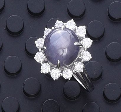 null 585th white gold ring, set with a cabochon of blue-grey star sapphire weighing...