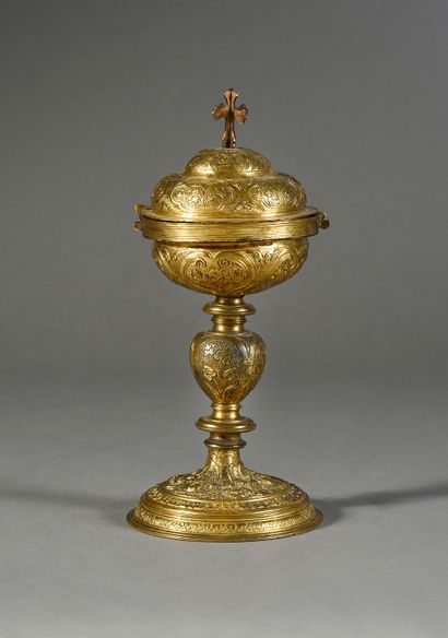 XVIe siècle Ciboire en cuivre ciselé et doré. Base circulaire avec masques, rinceaux,...