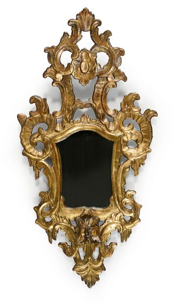 null Carved and gilded wooden mirror with a large openwork pediment, the bottom decorated...