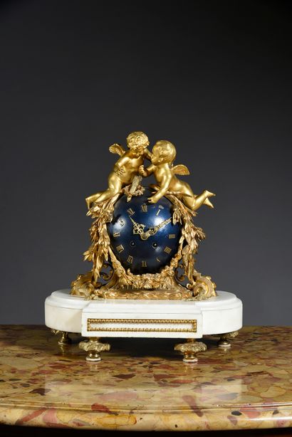 null Clock in chased and gilded bronze, featuring two putti on a blue steel globe...