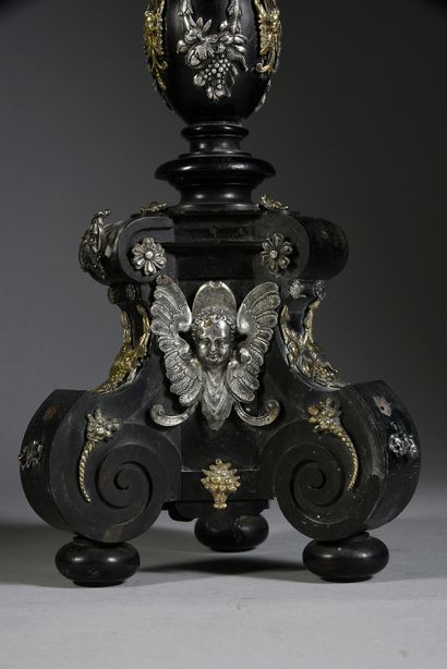 null Tripod candlestick in ebony and silver and gilt appliques, resting on console...