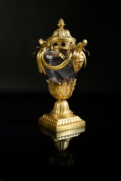 null A blown glass potpourri vase with a chased and gilded bronze mounting, resting...