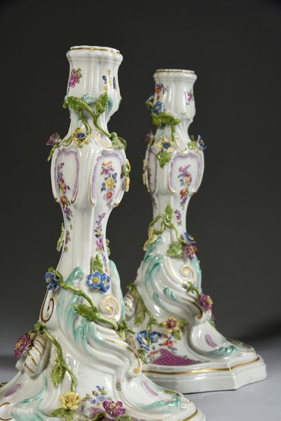 null Pair of porcelain candlesticks in the style of Meissen.
Of rocaille form, with...