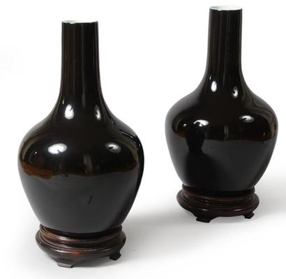 null Paire de vases en faïence noir, reposant sur des socles en bois. Chine, XX e...