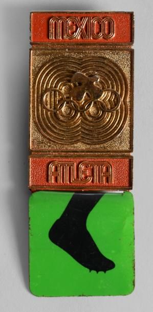 1968. Mexico Badge officiel. «Athlète». En métal doré. Dim. 36 x 68 mm.