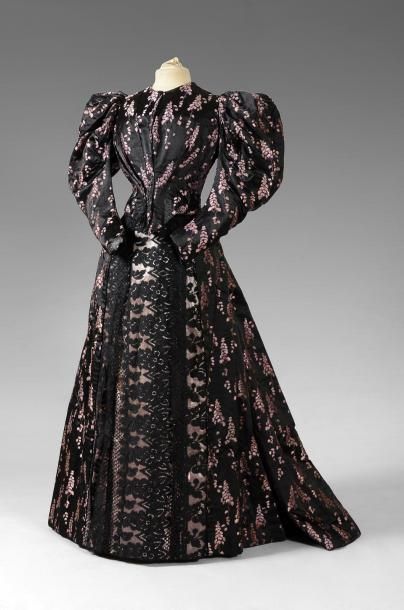 null Robe vers 1895, lampas fond damas noir liseré rose à dessin de rameaux fleuris...