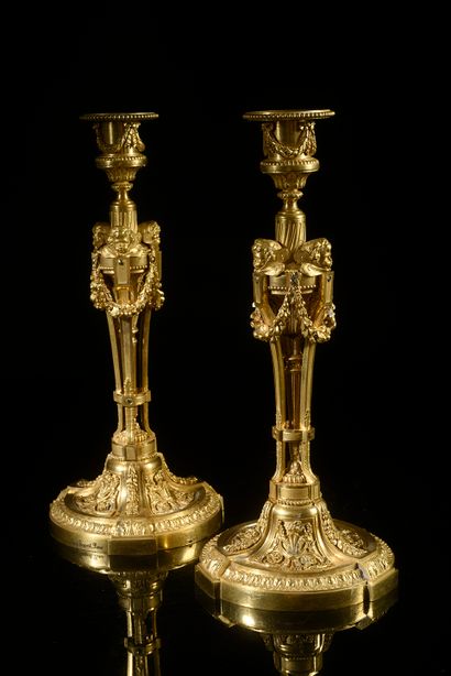 null Pair of chased and gilded bronze torches, the foot with friezes of heart-shaped...