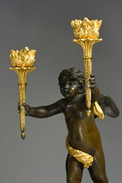 null Pair of chased bronze candelabras with patina and gilt, featuring putti holding...