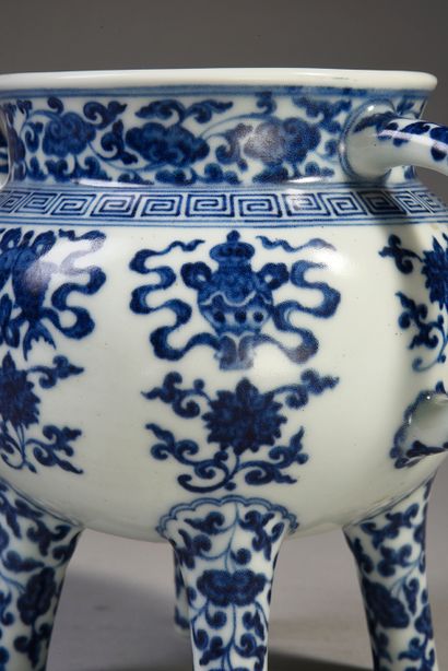 null Verseuse quadripode en porcelaine à décor blanc bleu de symboles bouddhistes.
Porte...