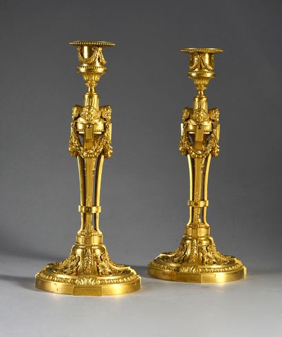 null Pair of chased and gilded bronze torches, the foot with friezes of heart-shaped...