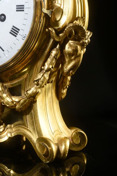 null Chased and gilded bronze clock, resting on scrolled feet, the enamelled dial...