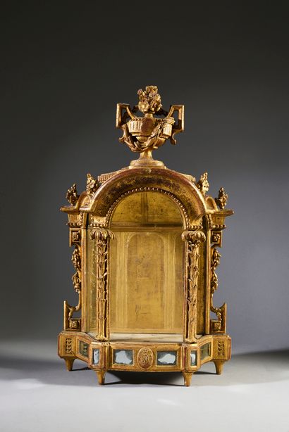 null Carved and gilded wood display case topped with a flowered urn and laurels,...