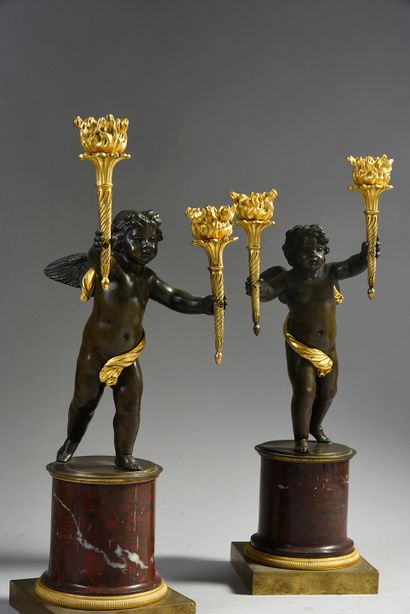 null Pair of chased bronze candelabras with patina and gilt, featuring putti holding...