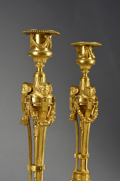 null Pair of chased and gilded bronze torches, the foot with friezes of heart-shaped...