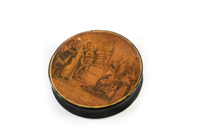 null TABATIÈRE.
En papier maché laqué noir, de forme ronde, ornée sur une face des...