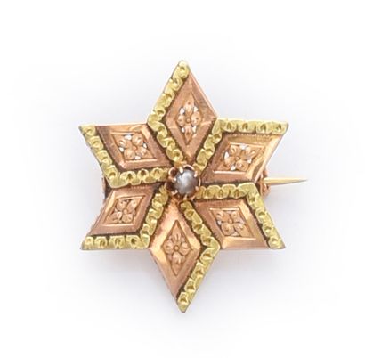 null Three-tone gold 750th star brooch, with chased decoration, the center set with...