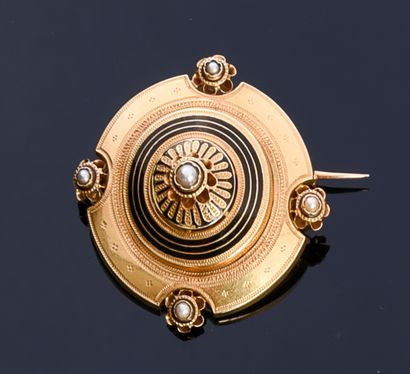 null Round brooch in 18K gold, finely chiseled decoration enhanced with black enamel,...