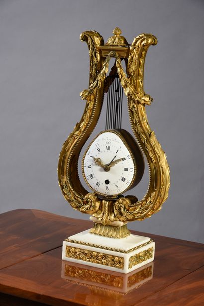 null Clock with the lyre in chased and gilded bronze.
White marble base with bronze...