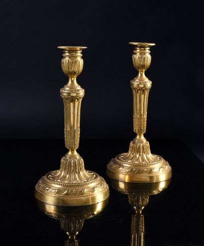 null Pair of chased and gilded bronze torches, the fluted shaft with asparagus, the...