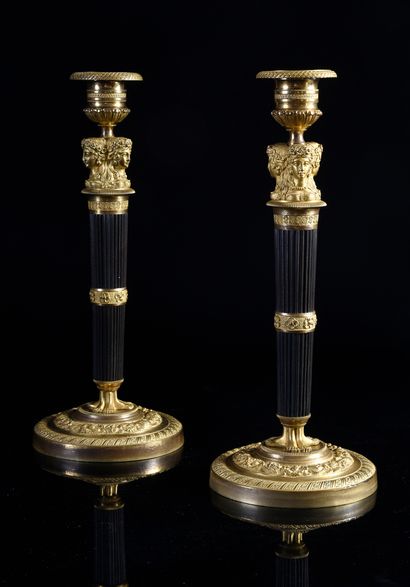 null Pair of torches in chased, patinated and gilded bronze, the godronné shaft with...