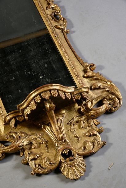 null Regency mirror, in carved and gilded wood, high pediment with openwork rose...