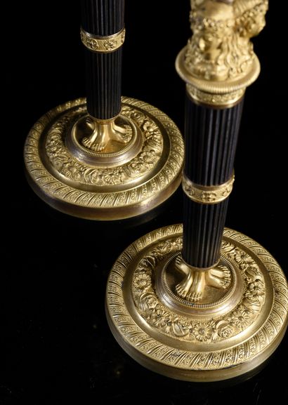 null Pair of torches in chased, patinated and gilded bronze, the godronné shaft with...