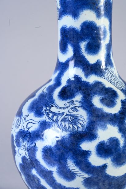 null Vase en porcelaine blanc bleu de Chine à décor d'un dragon dans des nuées. XXème...