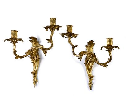 null Pair of sconces in chased and gilded bronze with two asymmetrical scrolled light...