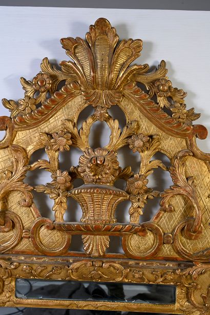 null Gilded wood mirror with carved shells and foliage, the openwork pediment decorated...