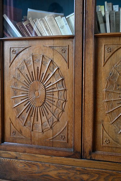 null Carved oak bookcase opening with two glass doors decorated with vellums and...
