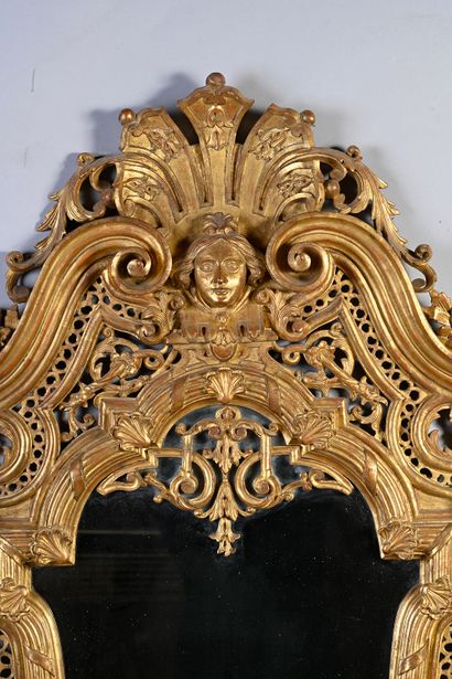 null Paire de miroirs en bois sculpté et doré et ajouré en forme d'écusson surmonté...