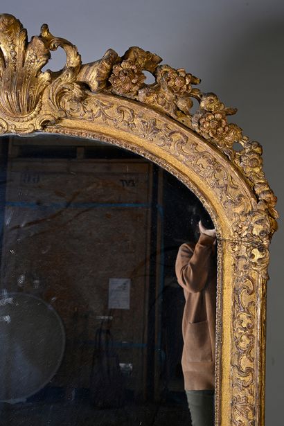 null Carved and gilded wood mirror decorated with foliage, the pediment decorated...