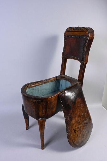 null Chaise formant bidet en bois mouluré et sculpté de fleurettes, l'assise garnie...