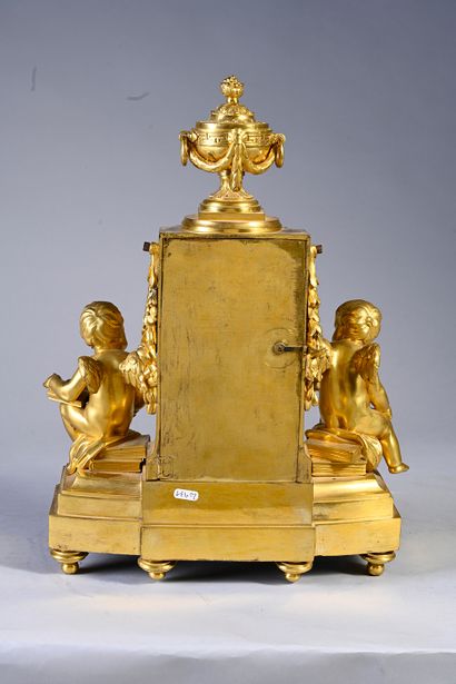 null Pendule en bronze ciselé et doré formée d'un fut de colonne cannelé, contenant...