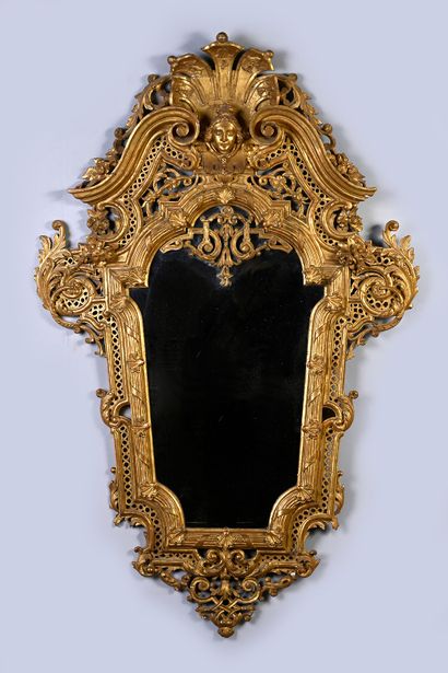 null Paire de miroirs en bois sculpté et doré et ajouré en forme d'écusson surmonté...