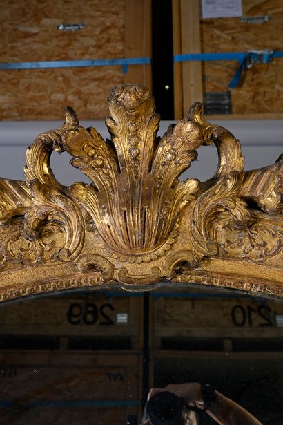 null Carved and gilded wood mirror decorated with foliage, the pediment decorated...