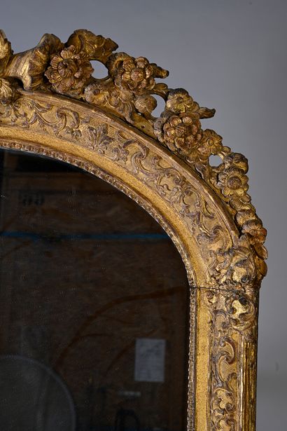 null Miroir en bois sculpté et doré à décor de rinceaux, le fronton orné de coquilles...