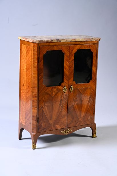 null Low bookcase in marquetry of veneer opening with two glazed doors in high part....