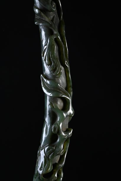 CHINE, XIXe siècle Sceptre ruyi en jade épinard
Sculpté en relief dans le goût naturaliste,...