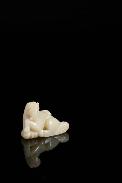 CHINE, XXe siècle Carved white jade pendant representing a horse carrying a monkey...